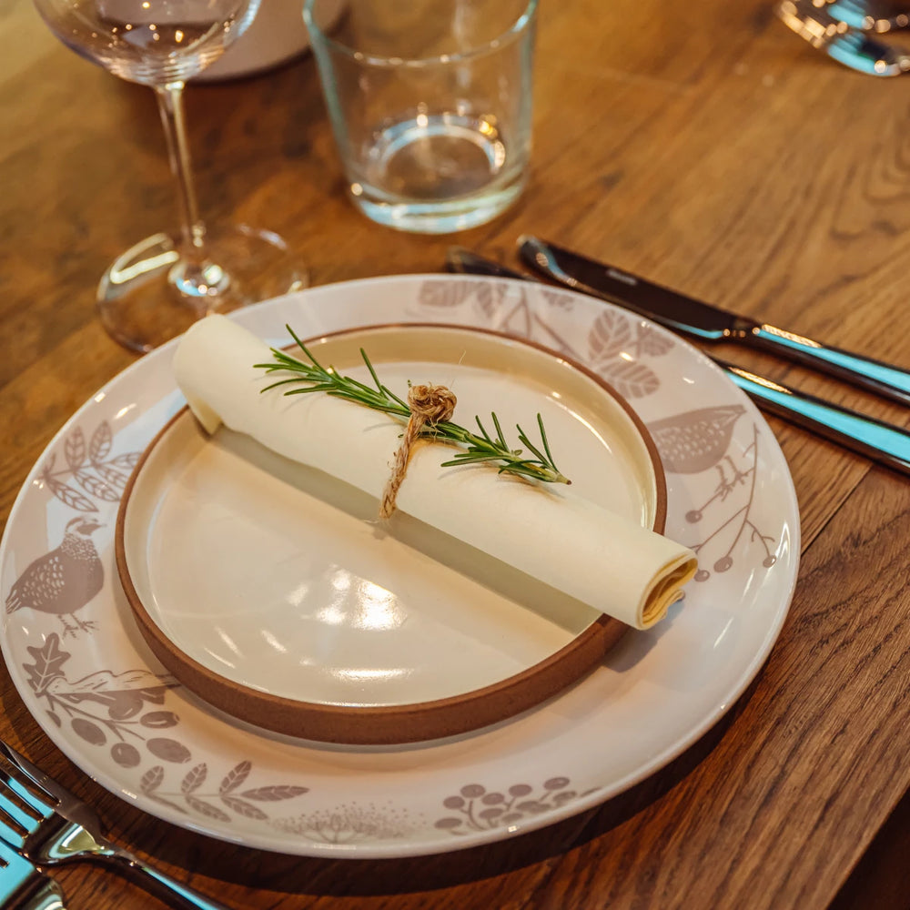 A place setting with rosemary tied into the napkin
