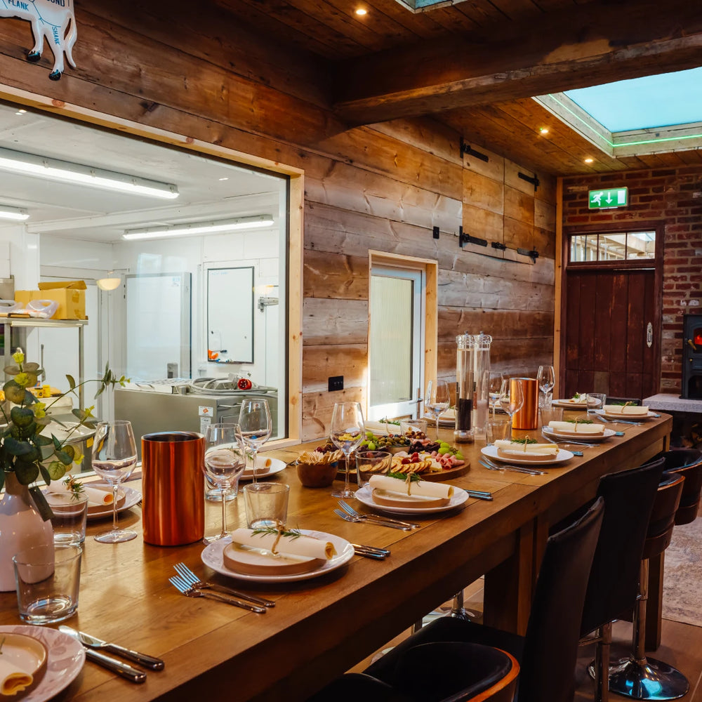 The long table laid for dinner beside the wood burner