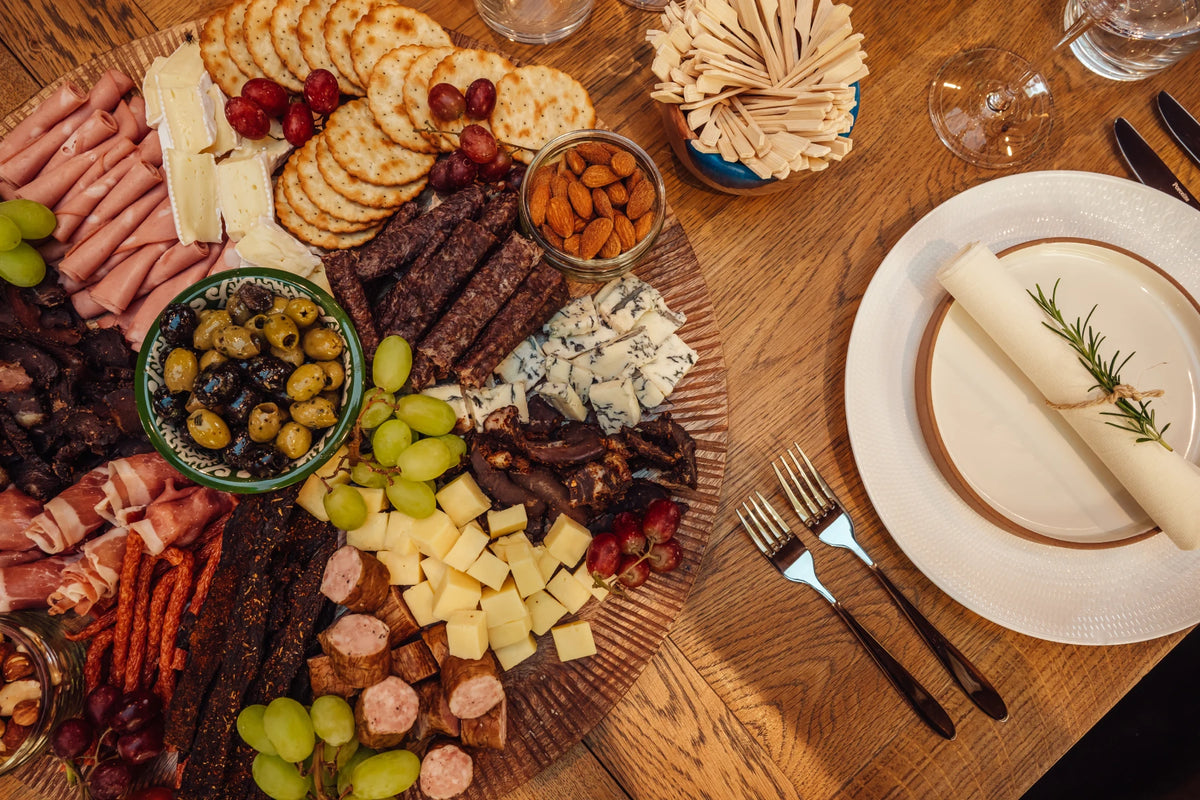 The ultimate charcuterie board beside a place setting